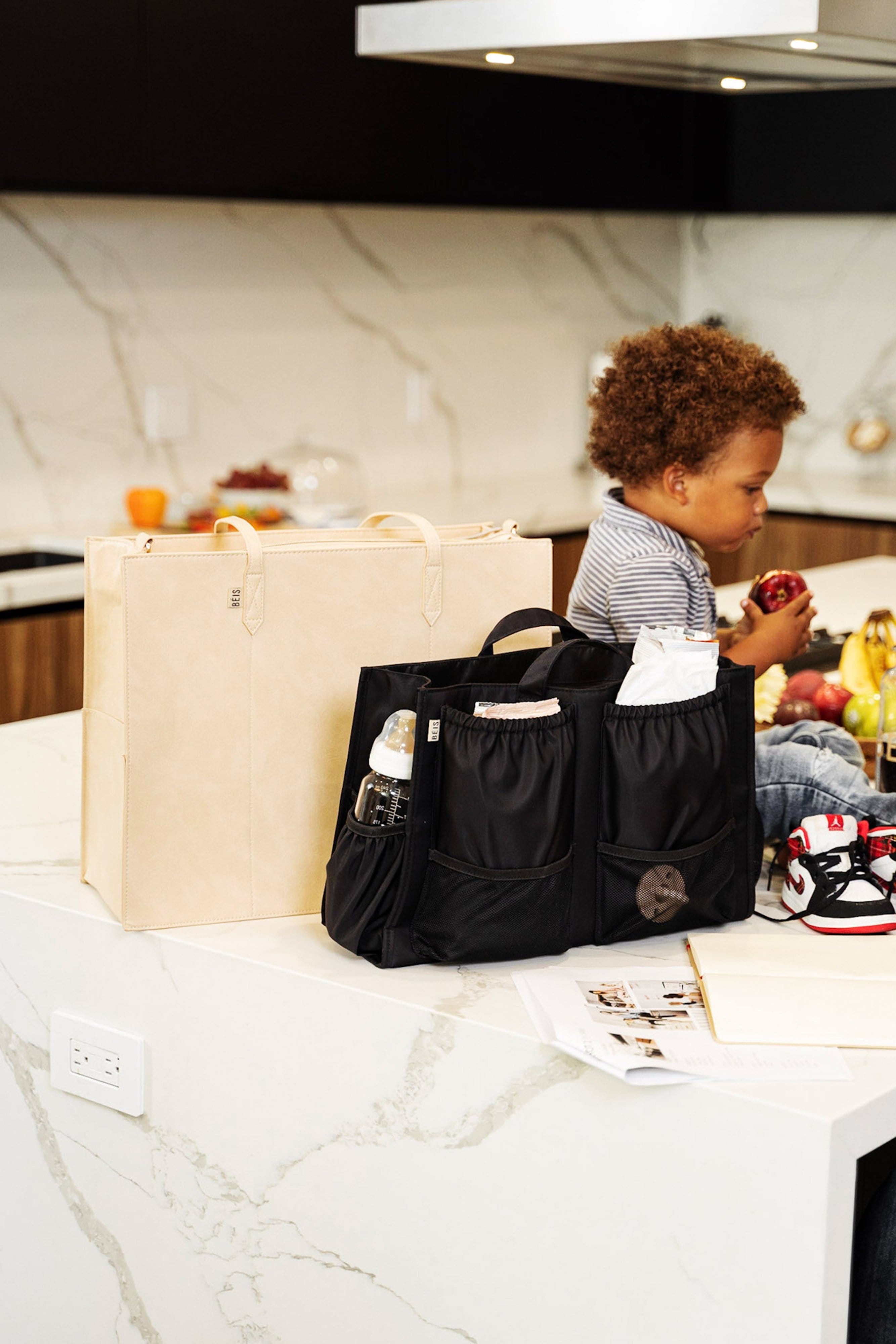 Tote Insert Black Filled with Diapers Bottle Wipes on Kitchen Counter with Baby